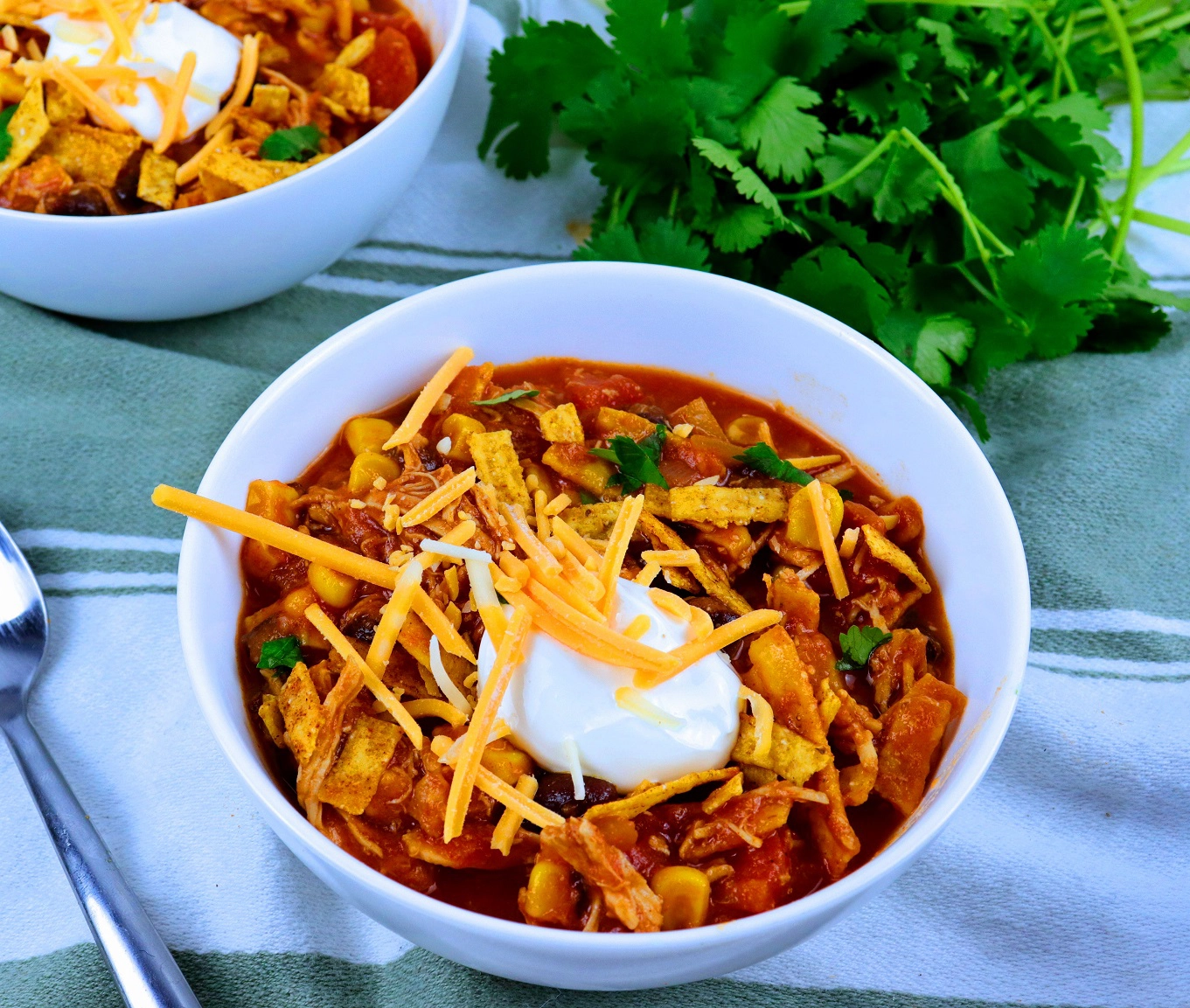 soup topped with sour cream and shredded cheese