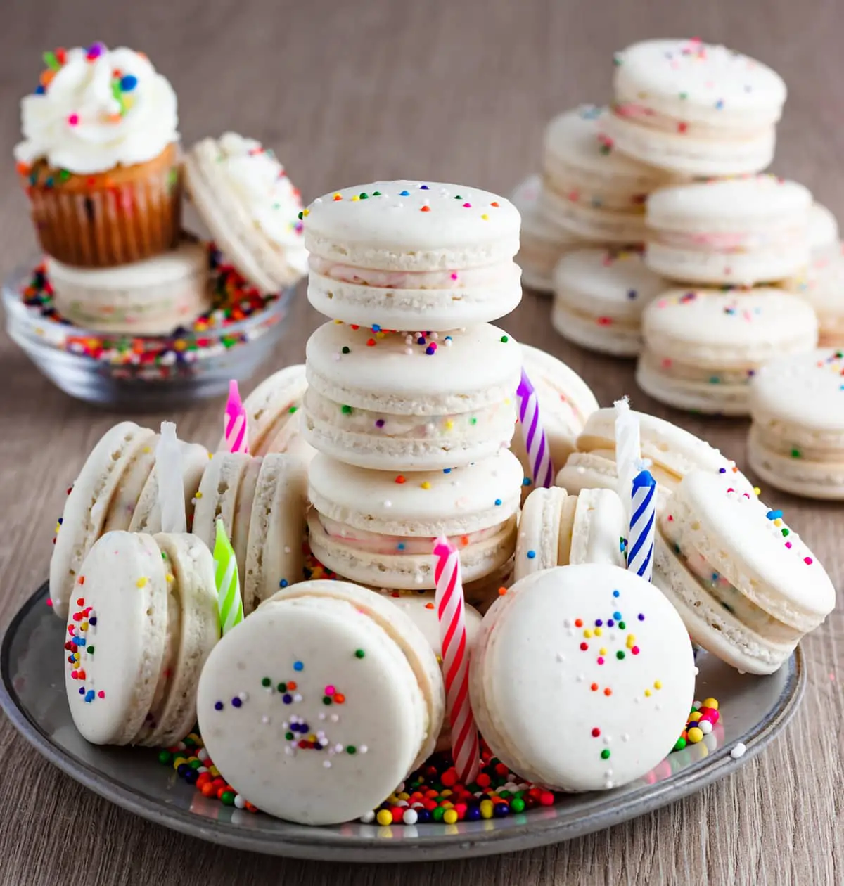 Cake macarons on a plate with candles and sprinkles