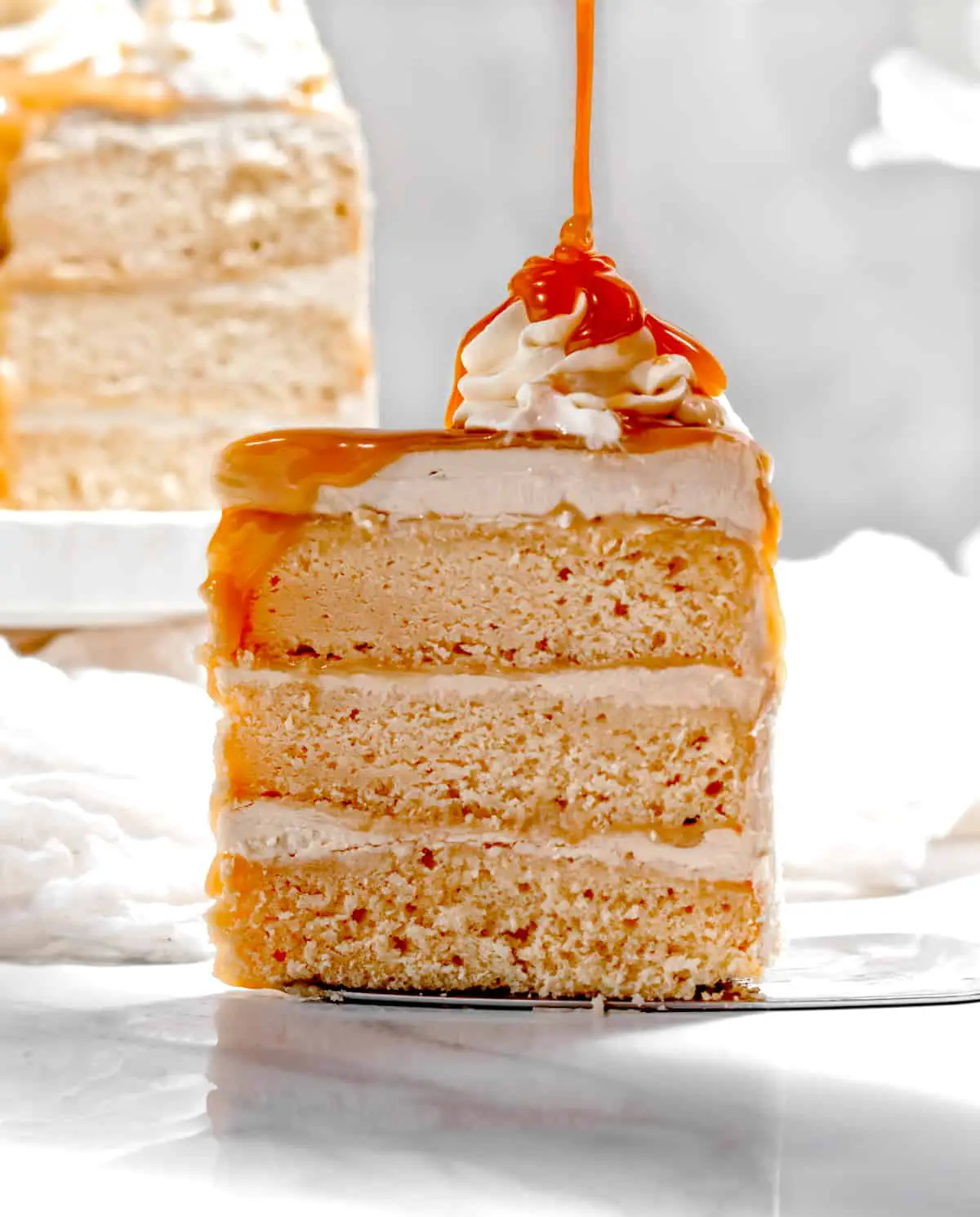 slice of cake on cake server with butterscotch drizzled on top