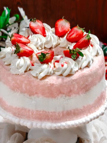 strawberry angel food cake with whipped cream and sliced strawberries