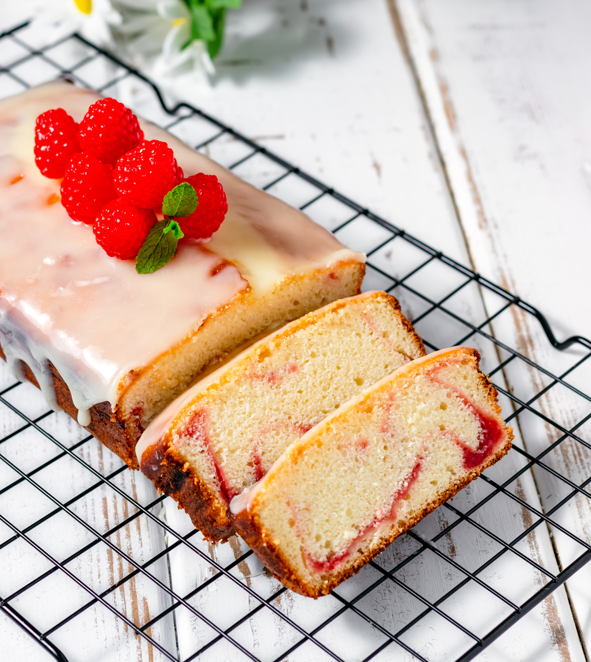 White Chocolate and Raspberry Loaf Cake on White Wood Table